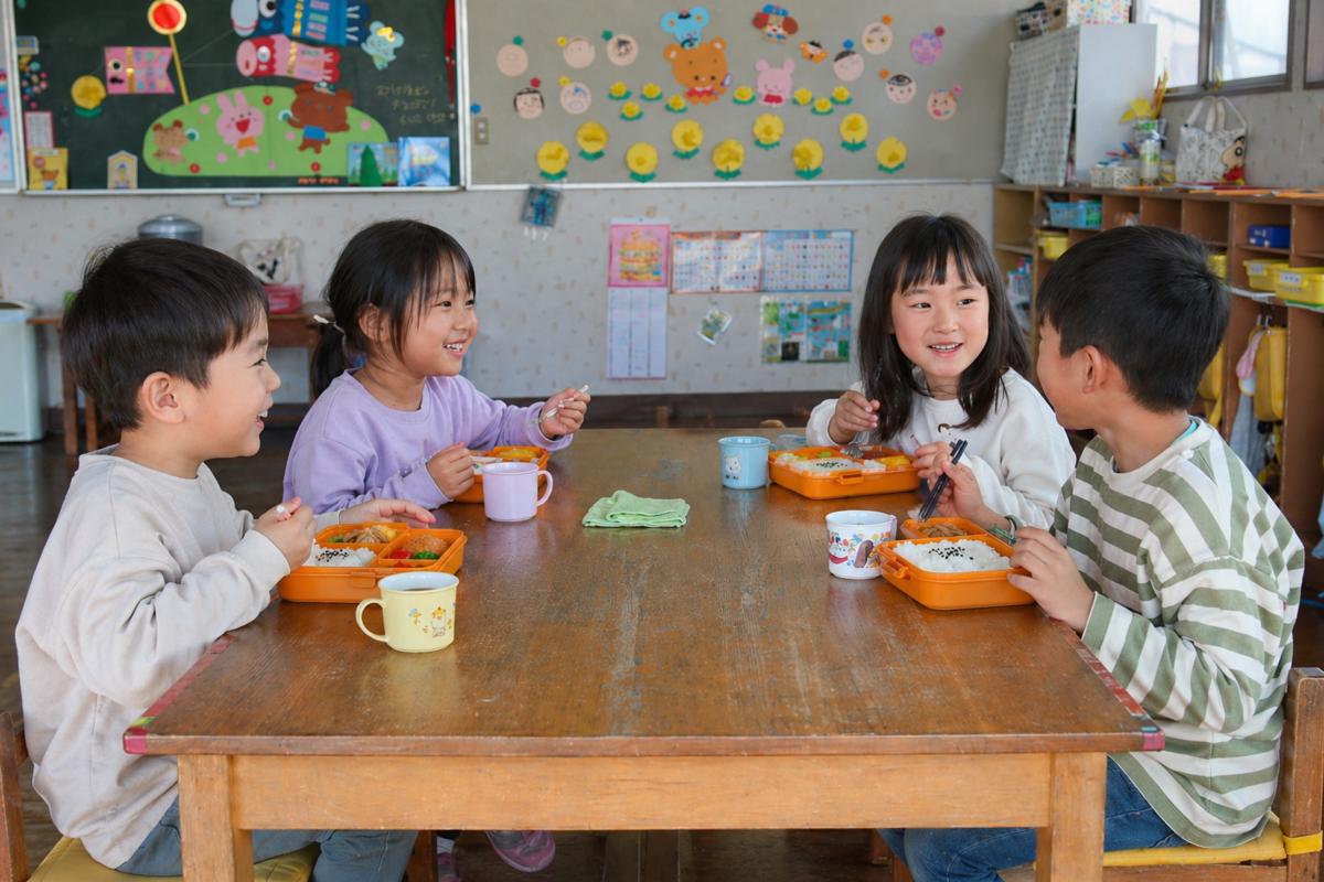 給食を笑顔で楽しむ子どもたち