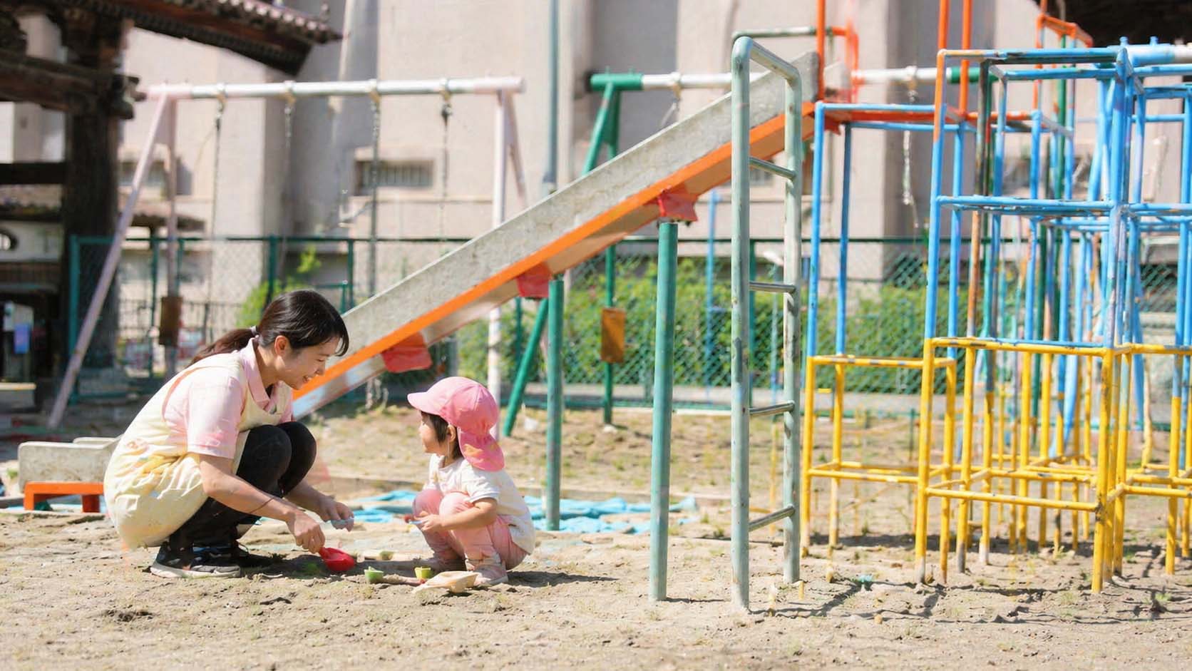 園庭で先生と子どもがあたたかく関わる様子
